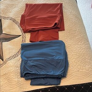 2 pair of LuLaroe leggings TC2. One is burnt orange the other is a teal blue.